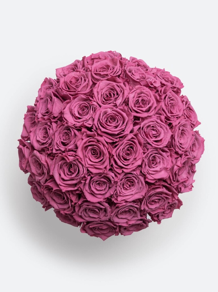 A symmetrical overhead view of 40 preserved roses in rich fuchsia tones, forming a perfect floral sphere with velvety petals.